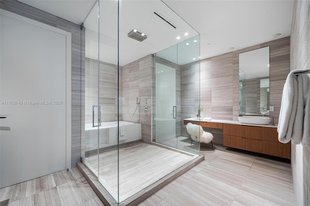 4701 N Meridian Ave Unit 603, Miami Beach, FL 33140 - bathroom with visible vents, vanity, a stall shower, a soaking tub, and tile walls