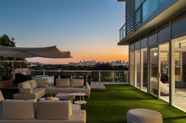 4701 N Meridian Ave Unit 603, Miami Beach, FL 33140 - patio terrace at dusk featuring a lawn, outdoor lounge area, and a balcony