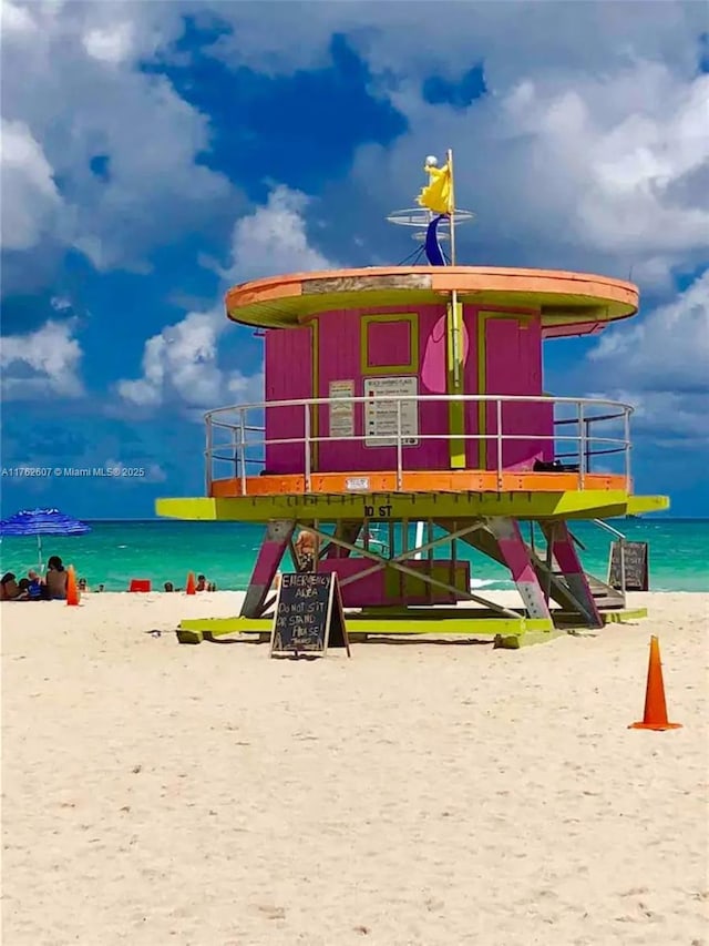 view of jungle gym featuring a view of the beach and a water view