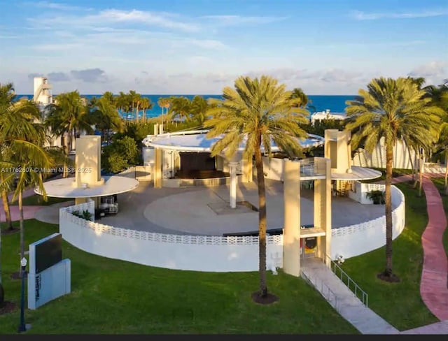 exterior space featuring a water view, a lawn, a patio, and outdoor dry bar