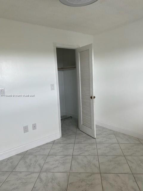 unfurnished bedroom featuring a closet and baseboards