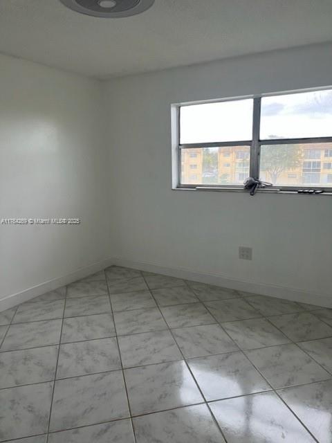 unfurnished room featuring baseboards