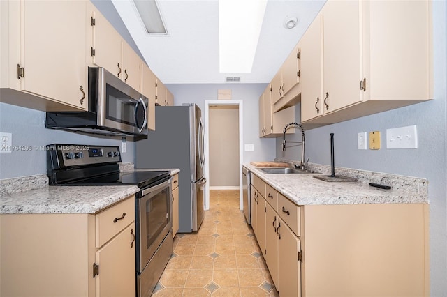 kitchen with light tile patterned floors, appliances with stainless steel finishes, light countertops, and a sink