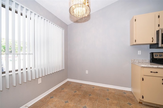 unfurnished dining area with tile patterned floors, a notable chandelier, and baseboards