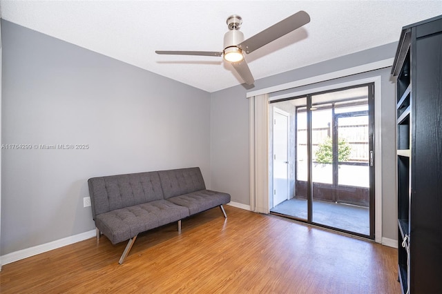 sitting room featuring light wood finished floors, ceiling fan, and baseboards