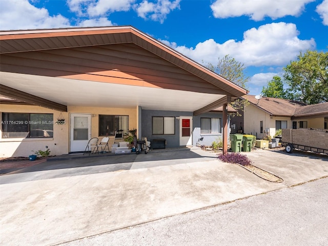 view of front of home with a patio, a carport, and stucco siding