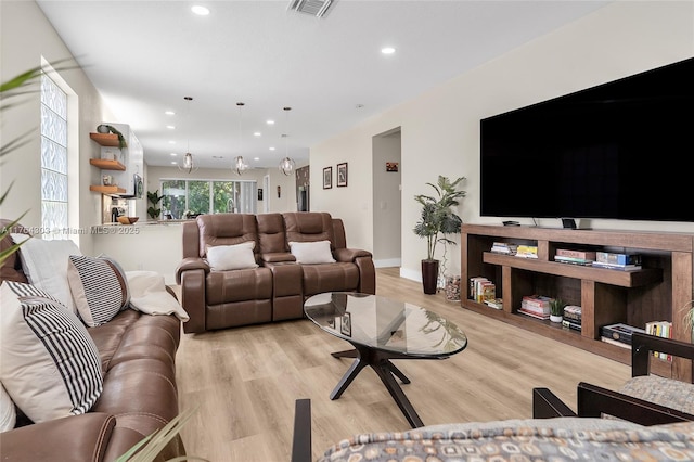 living room with light wood finished floors, visible vents, recessed lighting, and baseboards