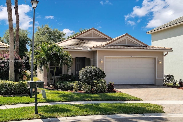 view of front of home featuring decorative driveway, a garage, and a tile roof