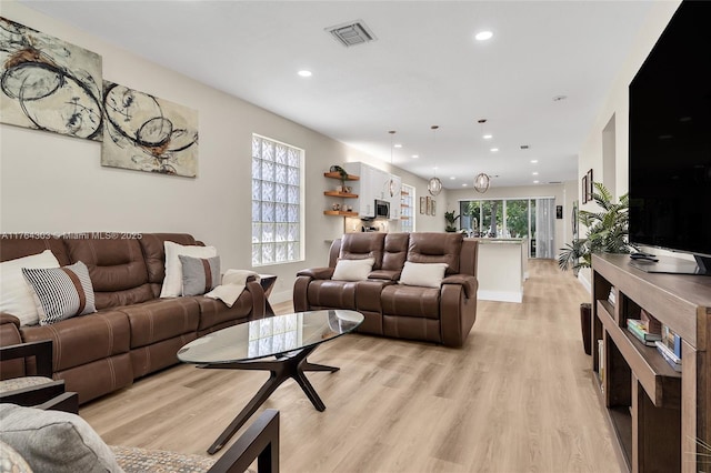 living area with recessed lighting, light wood-style floors, visible vents, and baseboards