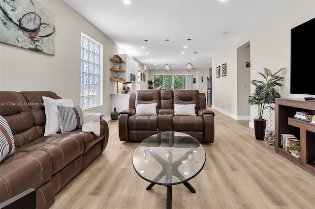 living area with recessed lighting, light wood-style floors, and baseboards