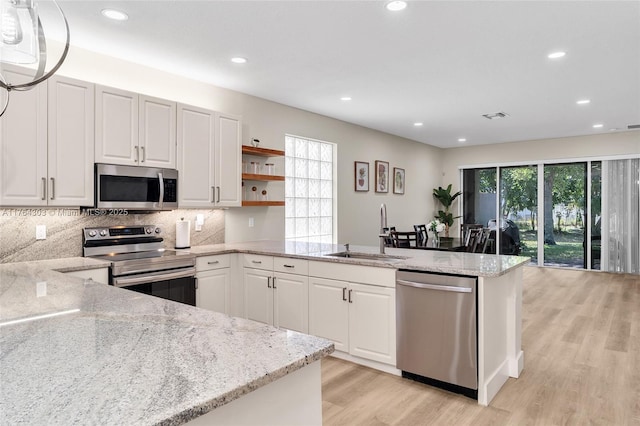 kitchen featuring a sink, plenty of natural light, appliances with stainless steel finishes, and a peninsula