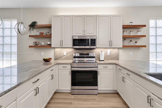 kitchen with white cabinets, appliances with stainless steel finishes, light wood-style floors, and open shelves