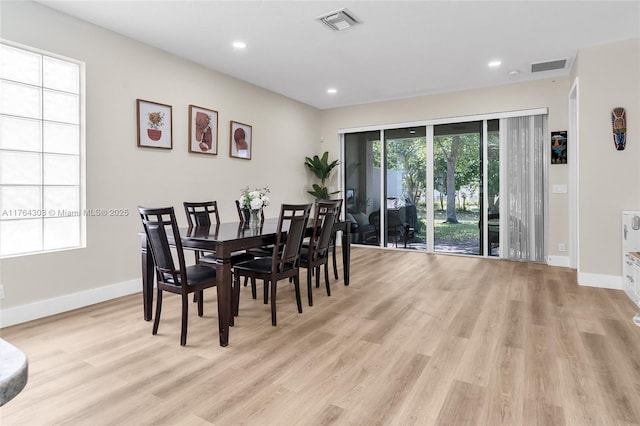 dining space with visible vents, baseboards, and light wood finished floors