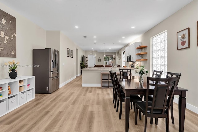 dining space with light wood finished floors, visible vents, recessed lighting, and baseboards