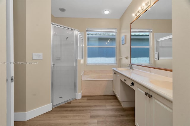 full bathroom featuring a shower stall, wood finished floors, a garden tub, and a sink