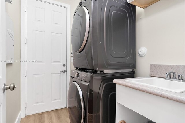 84 Belle Grove Ln, Royal Palm Beach, FL 33411 - washroom featuring stacked washing machine and dryer and light wood-style flooring