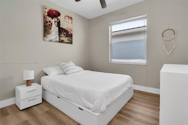 bedroom with a ceiling fan, wood finished floors, and baseboards