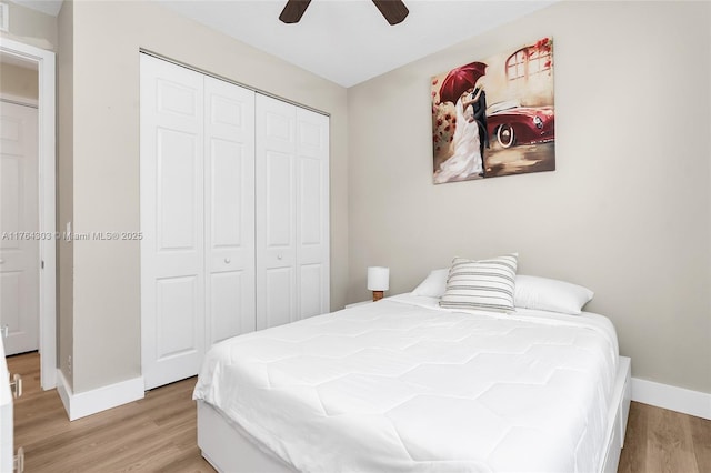 bedroom featuring light wood-style flooring, baseboards, a closet, and ceiling fan