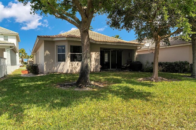 84 Belle Grove Ln, Royal Palm Beach, FL 33411 - rear view of house with stucco siding and a lawn