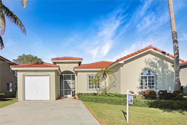 mediterranean / spanish home with stucco siding, driveway, a tile roof, a front yard, and an attached garage