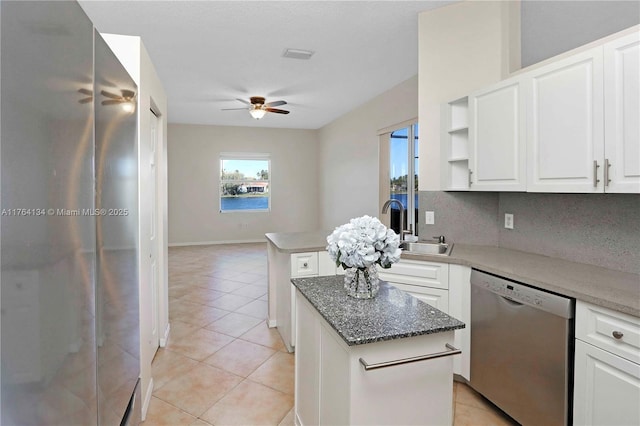 kitchen with light tile patterned floors, white cabinetry, a sink, ceiling fan, and dishwasher