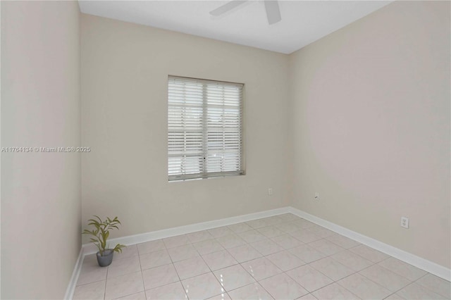 empty room with light tile patterned flooring, baseboards, and ceiling fan