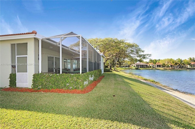 view of yard with a water view and a lanai