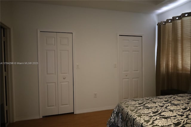 bedroom featuring dark wood finished floors and baseboards