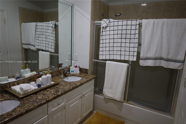 bathroom featuring a sink, double vanity, and combined bath / shower with glass door