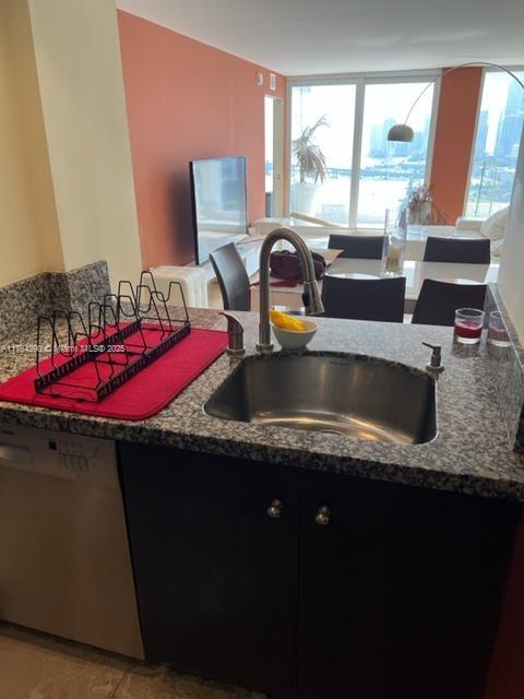 555 NE 15th St Unit 28J, Miami, FL 33132 - kitchen featuring dishwasher, a sink, plenty of natural light, and dark stone counters