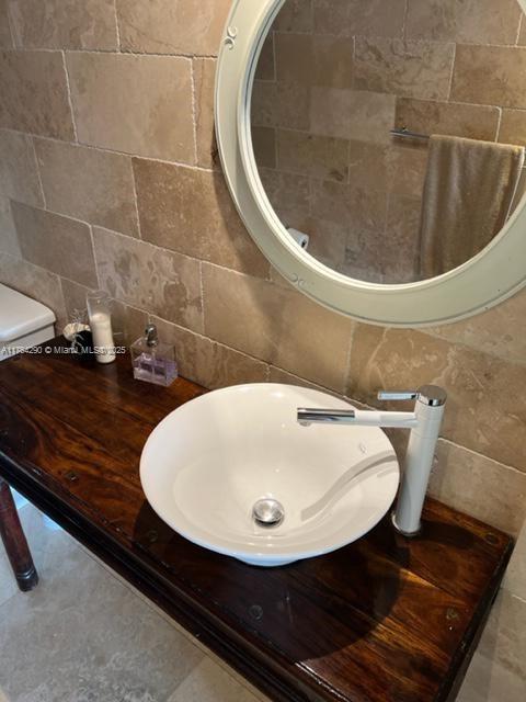 555 NE 15th St Unit 28J, Miami, FL 33132 - bathroom featuring tile walls, a sink, and tasteful backsplash