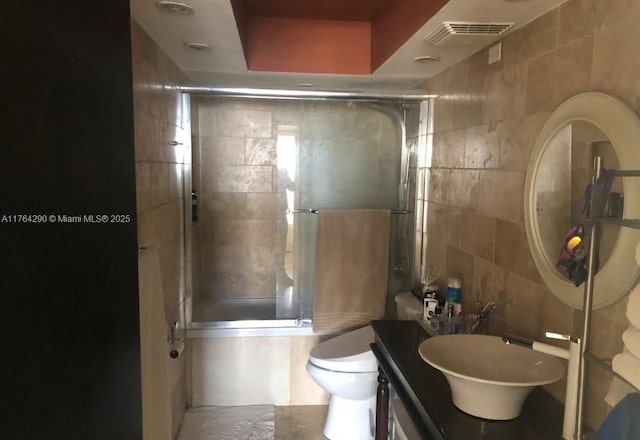 555 NE 15th St Unit 28J, Miami, FL 33132 - bathroom featuring tile walls, vanity, tiled shower / bath, and toilet