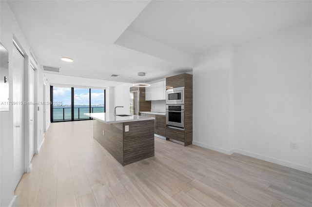 kitchen with visible vents, light wood finished floors, light countertops, appliances with stainless steel finishes, and modern cabinets