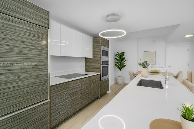 kitchen with light countertops, white cabinets, modern cabinets, stainless steel appliances, and a sink