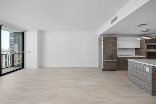 kitchen with visible vents, stainless steel appliances, a wall of windows, and modern cabinets