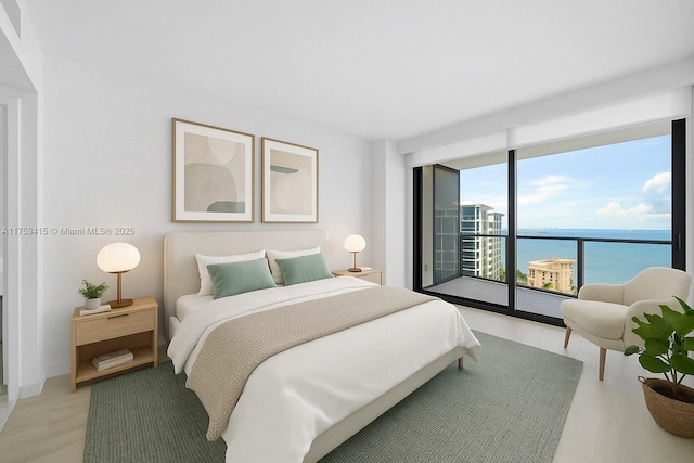bedroom with access to exterior, a wall of windows, and a water view
