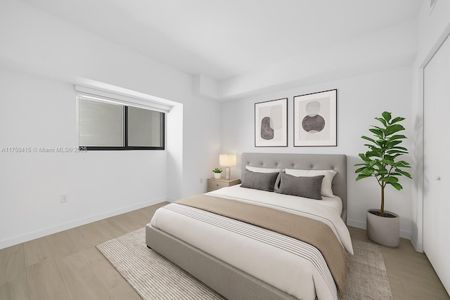 bedroom with baseboards and wood finished floors