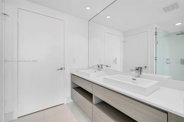 bathroom with a sink, visible vents, a shower stall, and tile patterned flooring