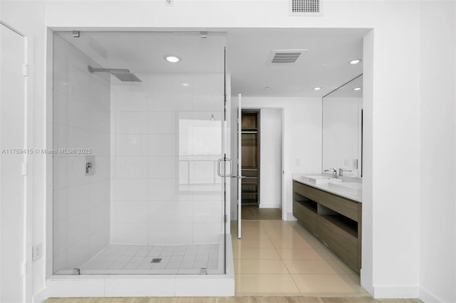 full bath featuring double vanity, visible vents, and a stall shower