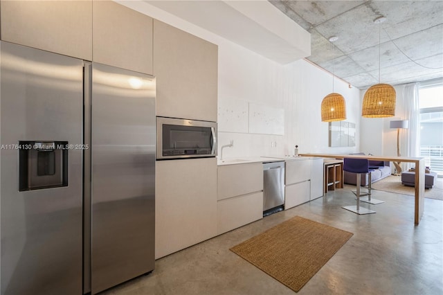 kitchen featuring concrete floors, light countertops, stainless steel appliances, modern cabinets, and a sink