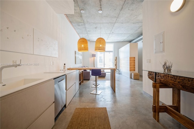 kitchen featuring modern cabinets, a sink, stainless steel dishwasher, concrete floors, and hanging light fixtures