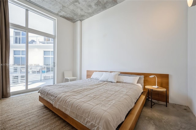 bedroom featuring access to exterior and concrete flooring