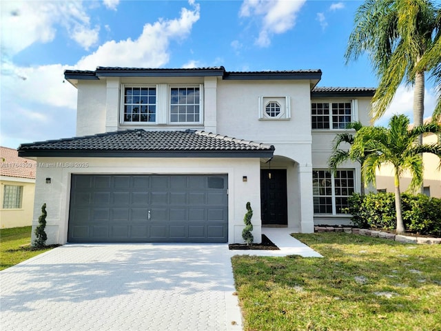 view of front of property featuring a front yard, decorative driveway, a garage, and stucco siding