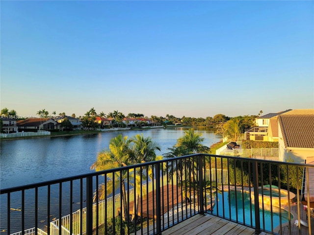 deck with a water view and a pool with connected hot tub