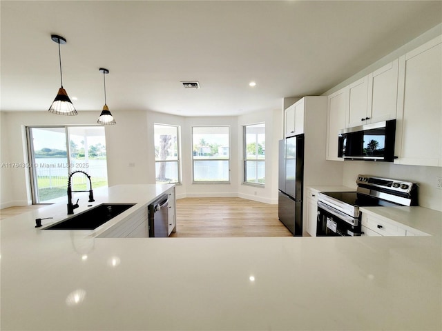 kitchen with light countertops, visible vents, appliances with stainless steel finishes, and a sink