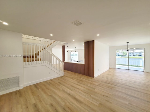 spare room with an inviting chandelier, recessed lighting, visible vents, and light wood-type flooring