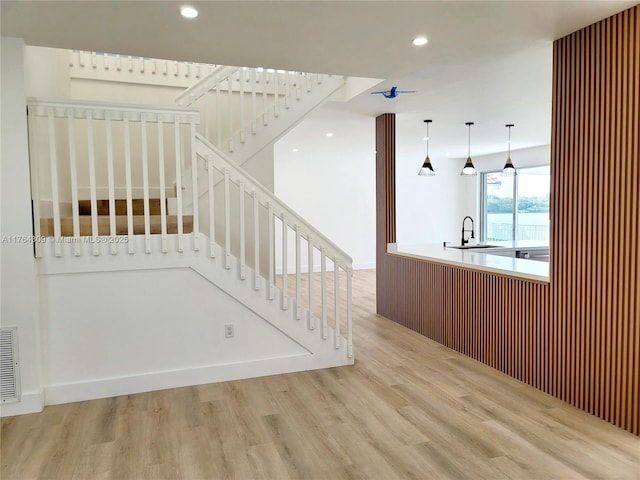 stairs with recessed lighting and wood finished floors