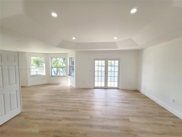 unfurnished room featuring light wood-style flooring, plenty of natural light, recessed lighting, and a raised ceiling