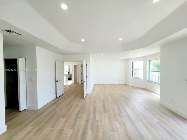 unfurnished room featuring light wood finished floors, visible vents, recessed lighting, and baseboards