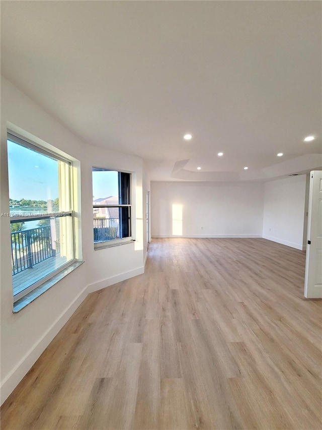 spare room featuring recessed lighting, light wood-style flooring, and baseboards